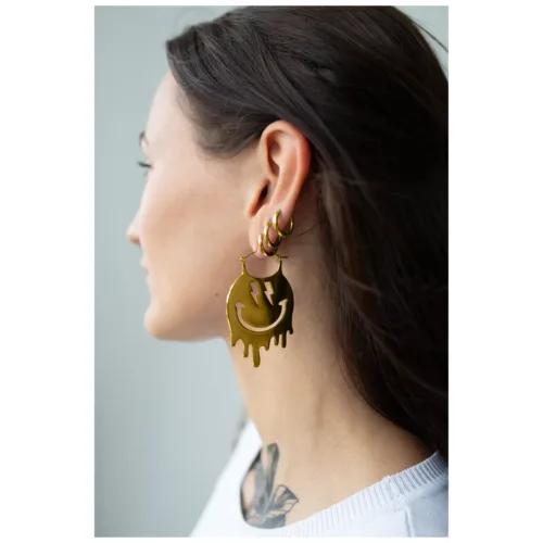 Frau mit Smiley Big Hoops Ohrringen aus goldenem Metall