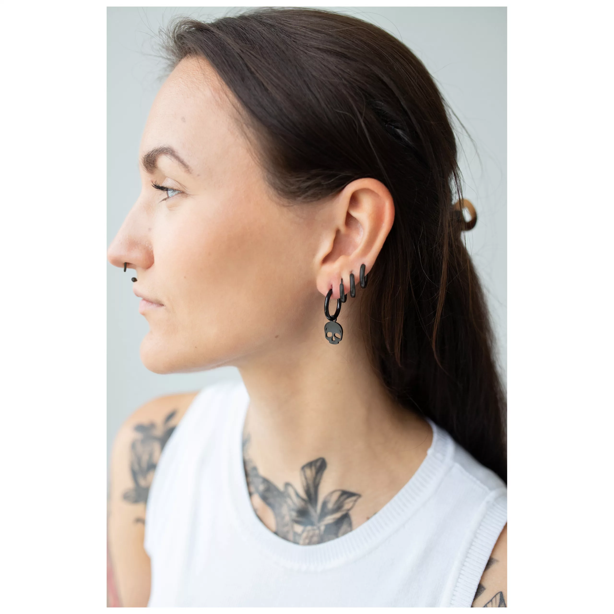 Frau mit schwarzen Little Skull Hoops Ohrringen aus Chirurgenstahl
