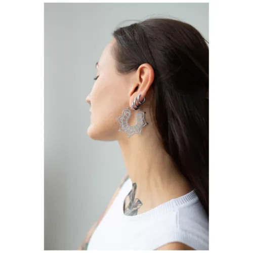 Frau mit langen Haaren trägt silberne Magnolia Hoops Ohrringe