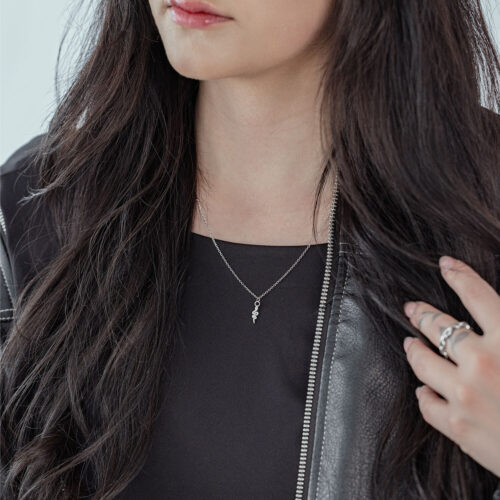 Frau mit langer, dunkler Haaren trägt eine silberne Little Snake Kette und einen schwarzen Lederjacke