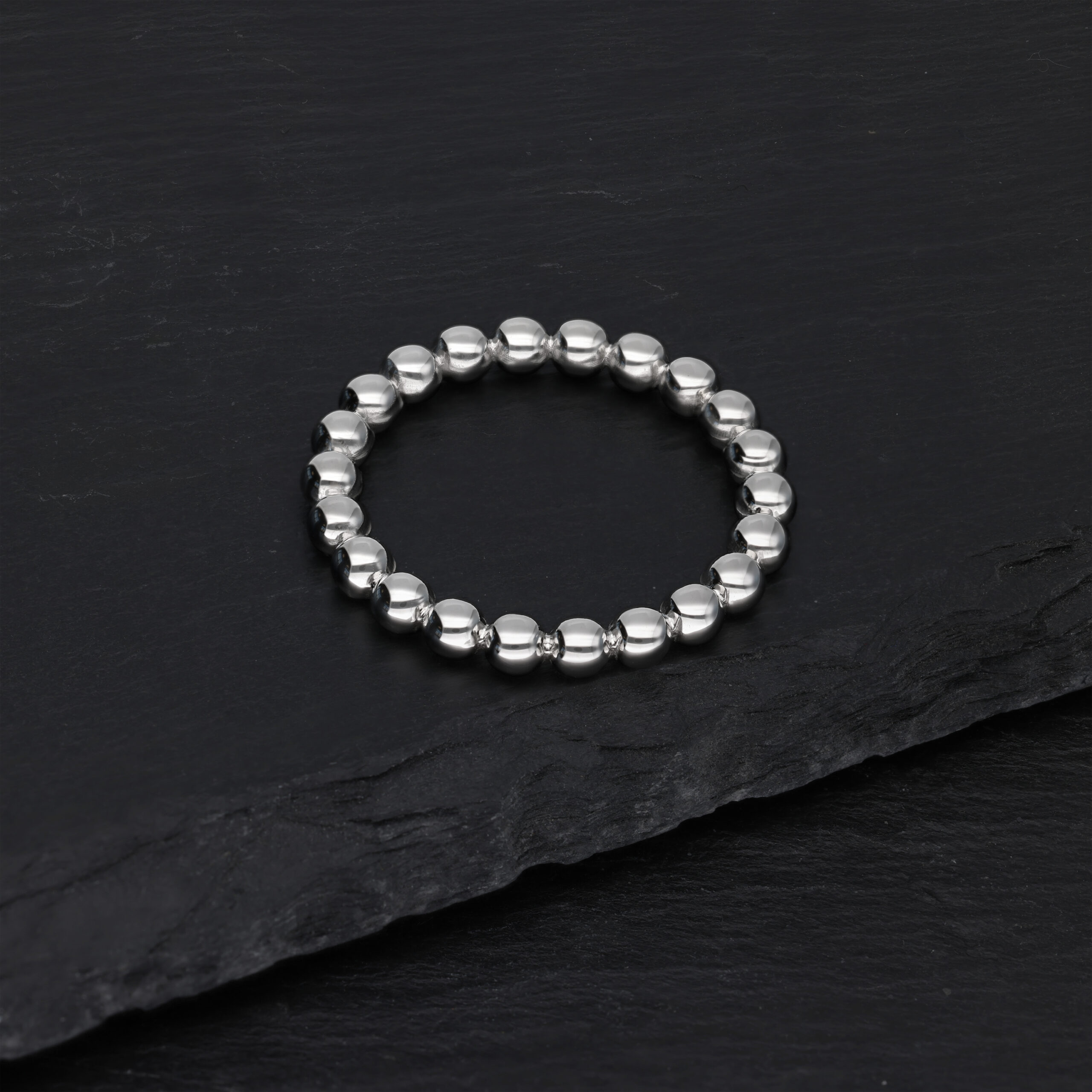 Silberner Bubble Ring auf schwarzem Hintergrund liegend