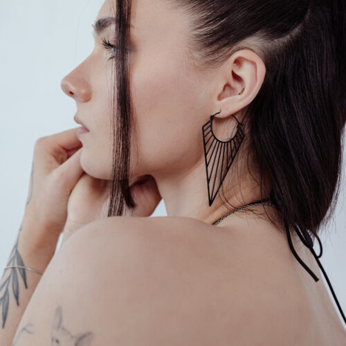 Schwarze Prisma Hoops Ohrringe an einer Frau mit braunem Haar, seitlich fotografiert