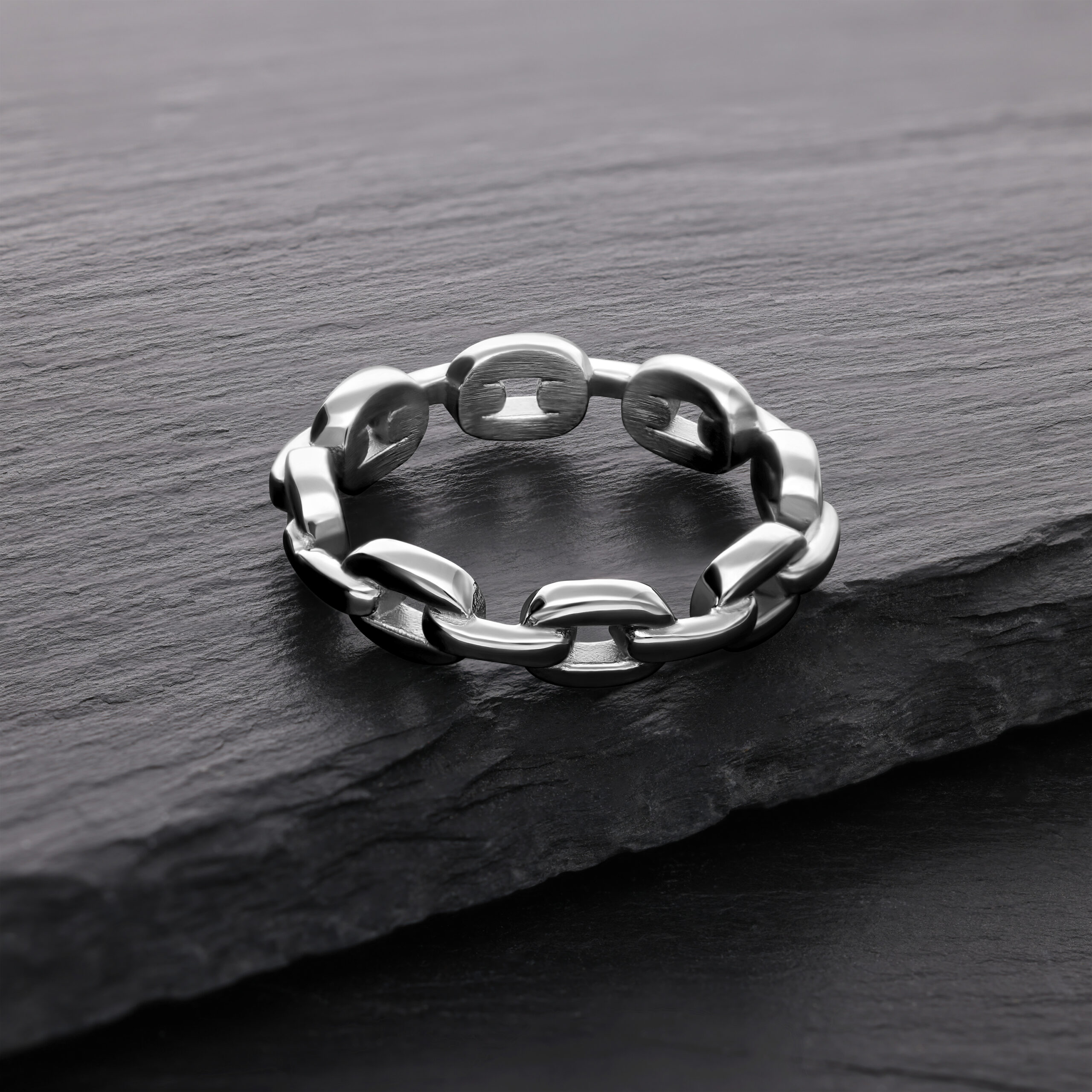 Silberner Link Chain Ring aus Chirurgenstahl auf dunklem Stein