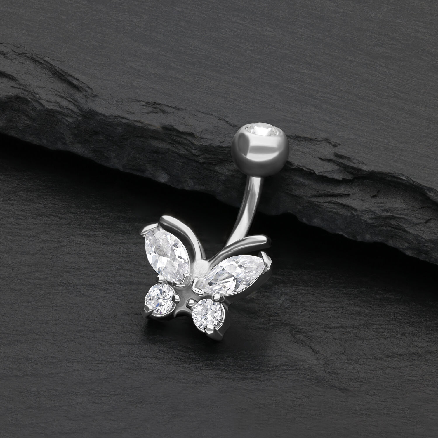 Silbernes Bauchnabelpiercing mit Schmetterling und klaren Kristallen auf schwarzem Hintergrund
