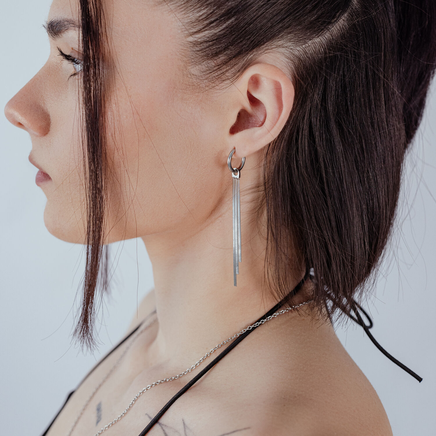Frau mit silbernen Snakechain Ohrringen, seitliche Ansicht