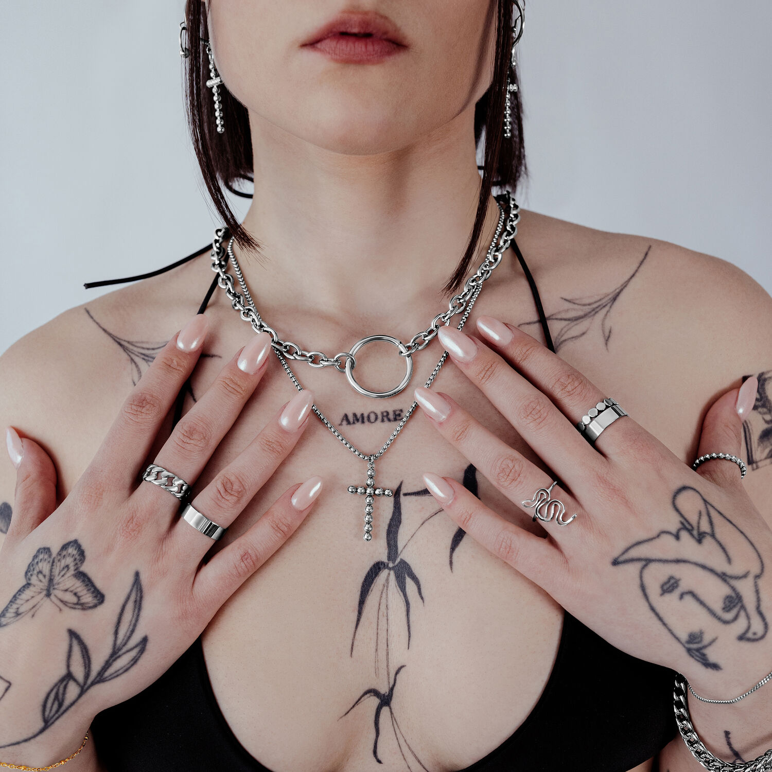 Frau mit Bubble Cross Halskette in Silber auf neutralem Hintergrund