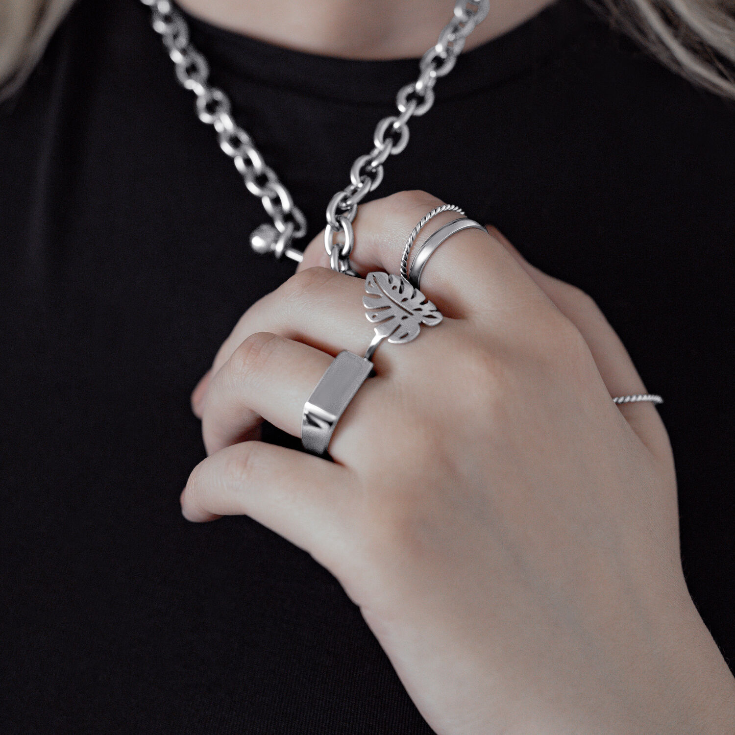 Silberner Monstera Blatt Ring an Hand, getragen mit anderen Ringen