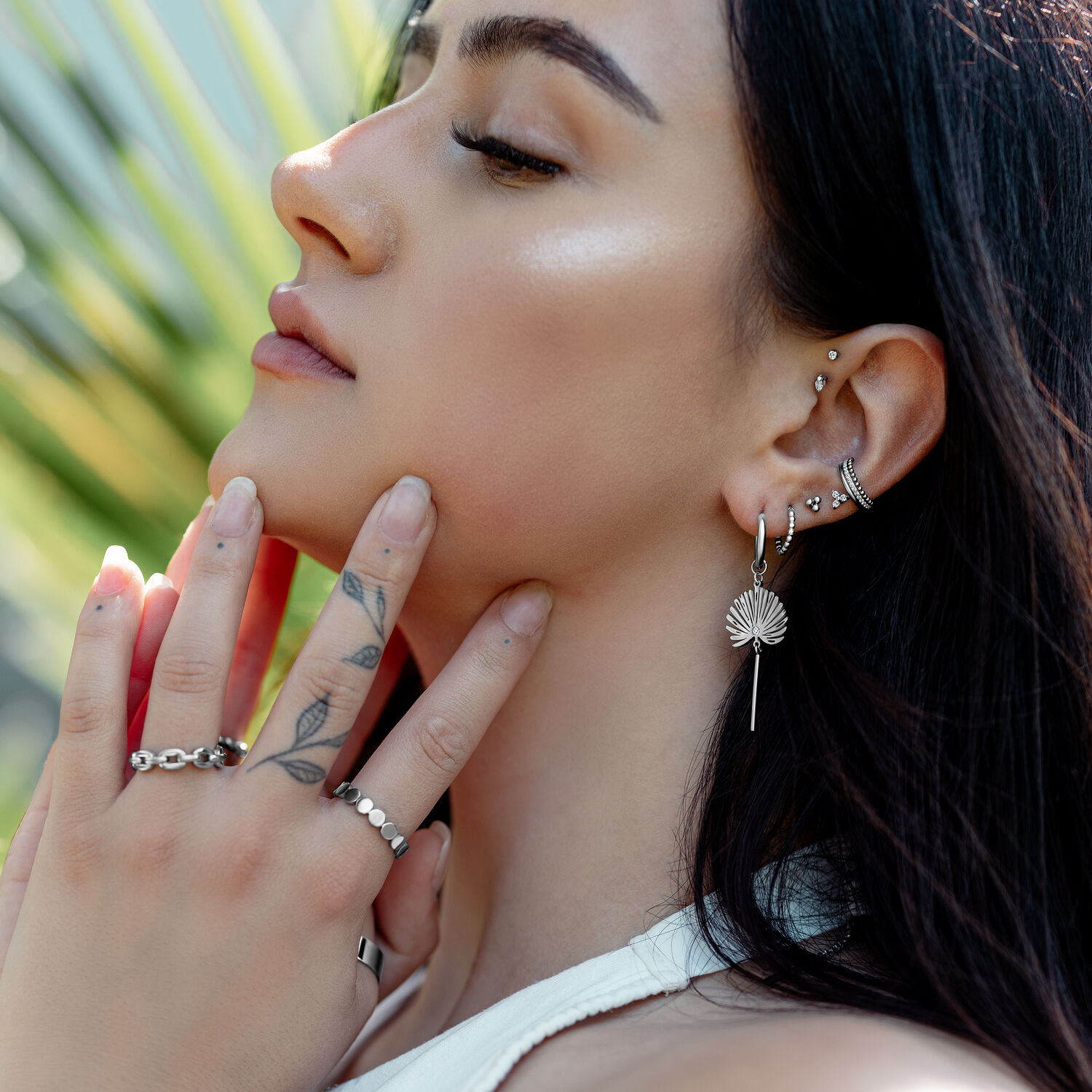 Frau mit mehreren Ohrringen, darunter Little Petticoat Hoops, im Ohr, im Freien