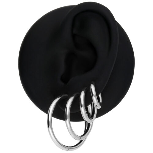 Set aus drei silbernen Ohrringen an schwarzem Ohrmodell