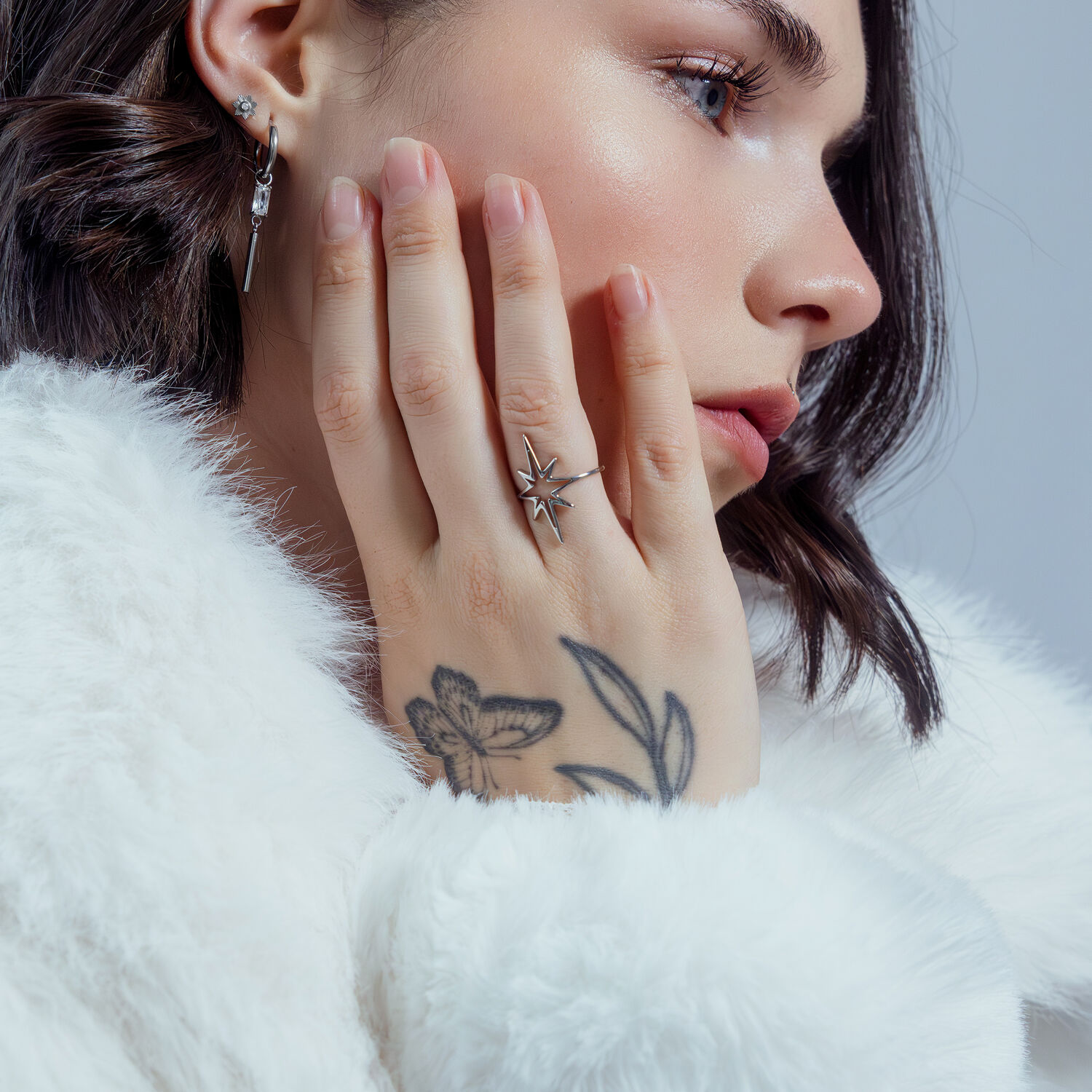 Frau mit Polar Star Ring aus Chirurgenstahl, Nahaufnahme, weißer Hintergrund