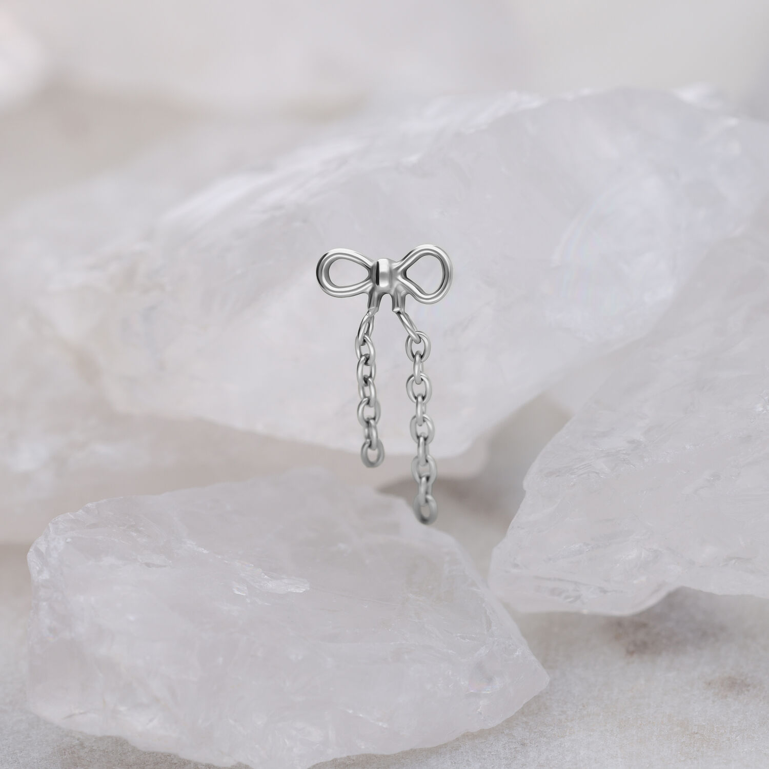 Titan Aufsatz mit Ketten in Schleifenform Silberner Push Fit Schleifenaufsatz mit Ketten auf hellem Hintergrund