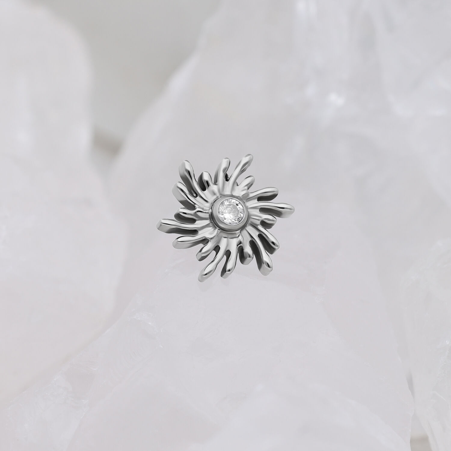 Silberner Sunburst Aufsatz mit kristallklarem Stein auf weißem Hintergrund