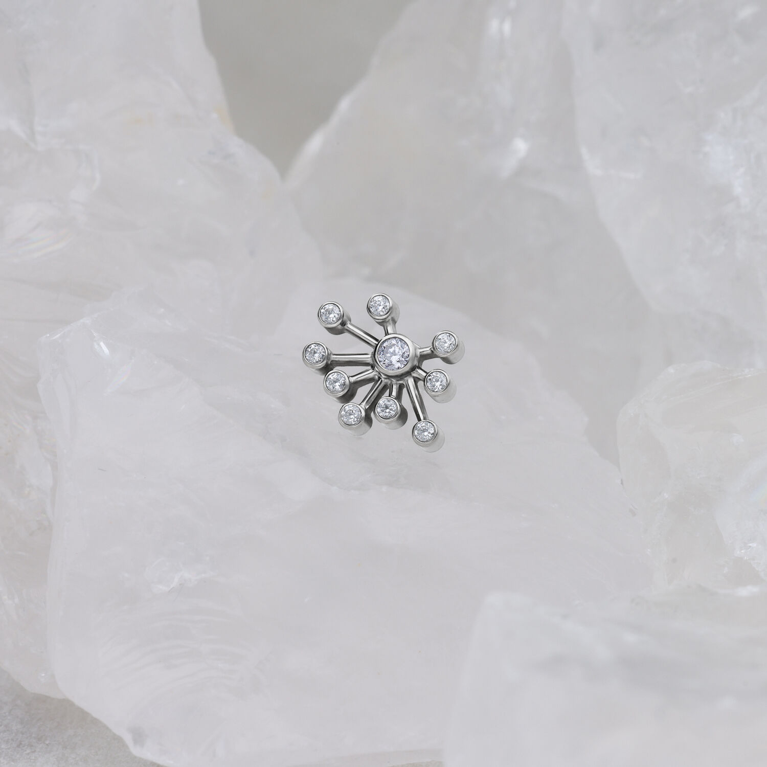 Silberfarbener Push Fit Aufsatz auf weißem Hintergrund aus Kristallen