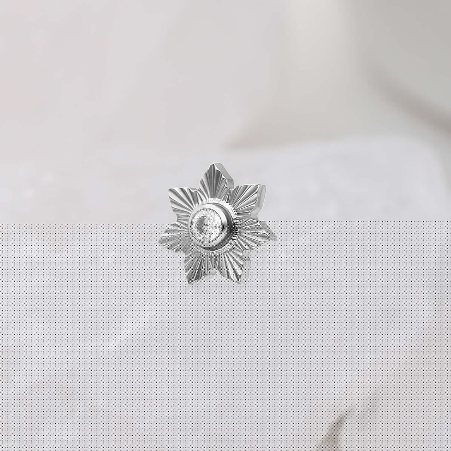 Silberner sternförmiger Push Fit Aufsatz mit klarem Kristall auf weißem Hintergrund