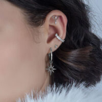 Silberner Helix Aufsatz mit Kristallen an einem Ohr, dunkler Hintergrund